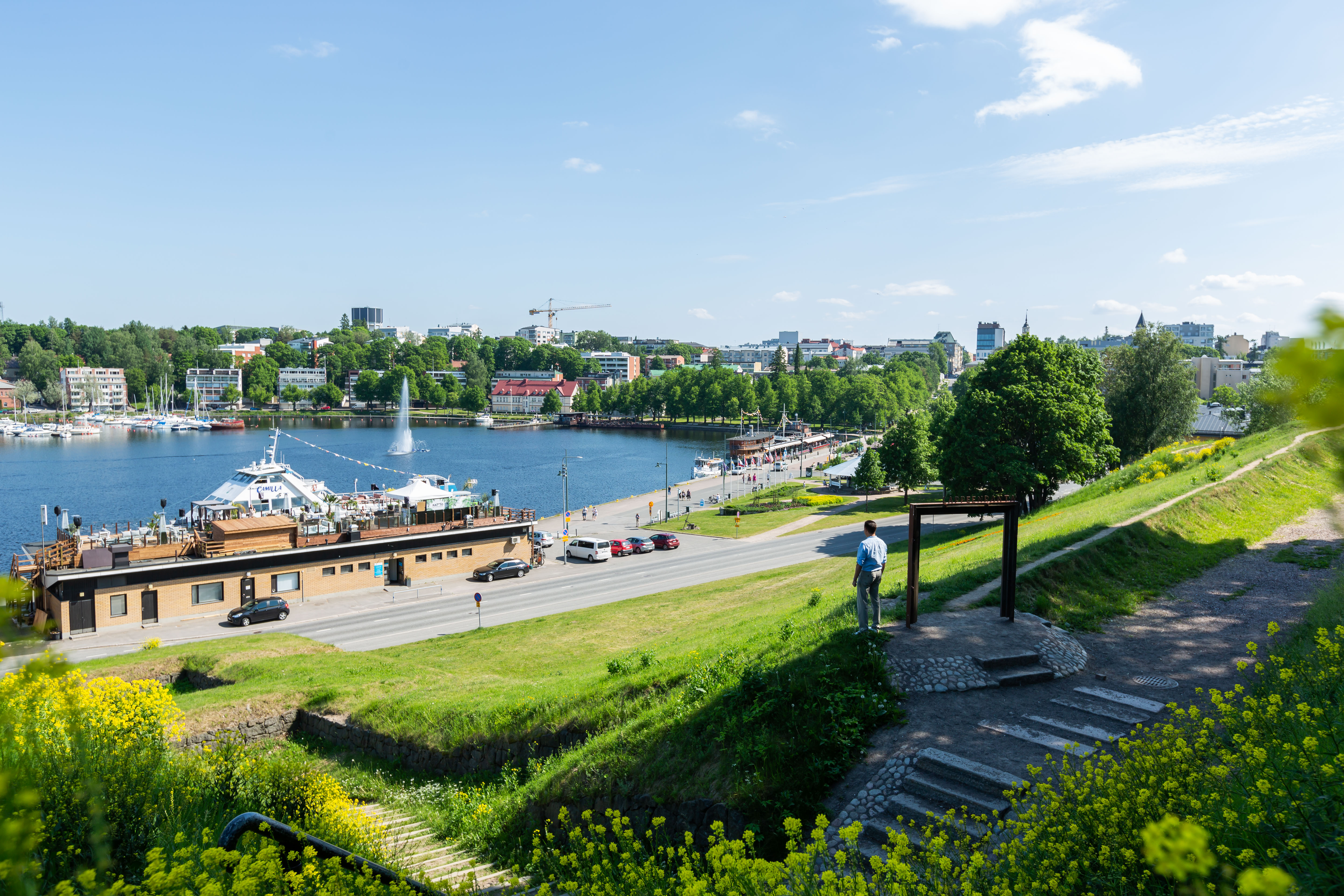 Mies katsoo alas kaupunginlahdelle Linnoituksen vallilta.