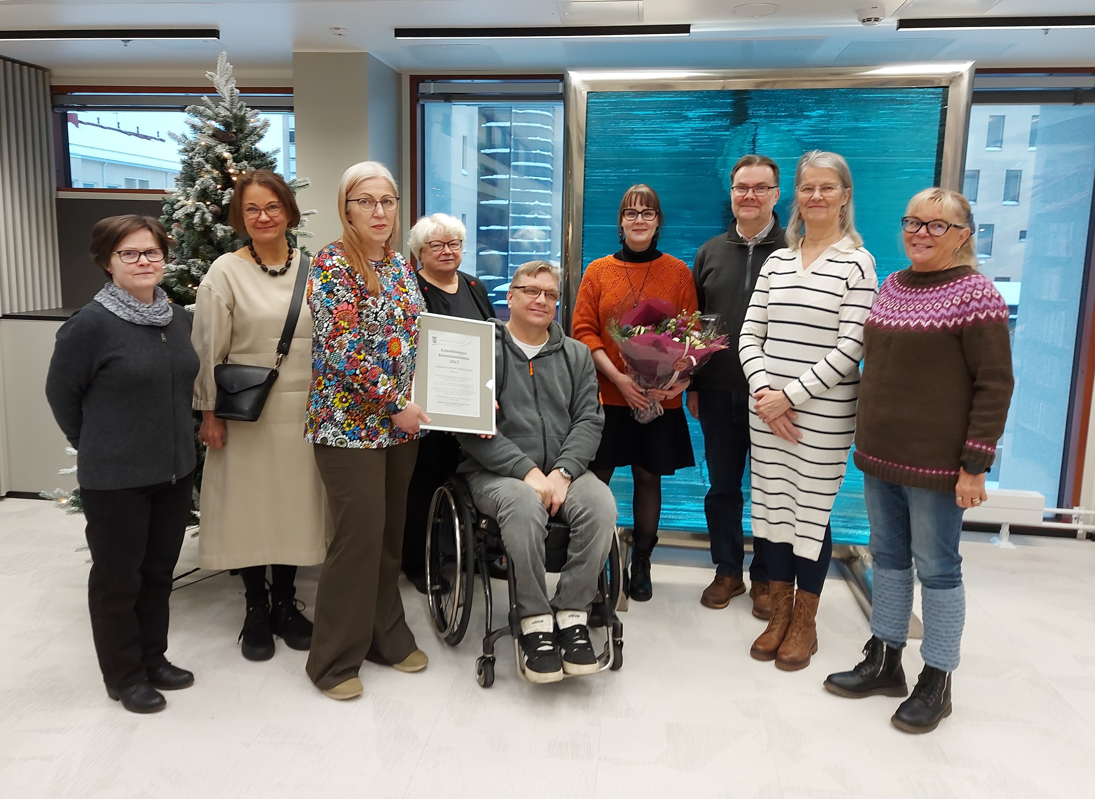 Vammaisneuvoston ja kirjaston edustajia sekä esteettömyyskunniamaininnan kunniakirja.
