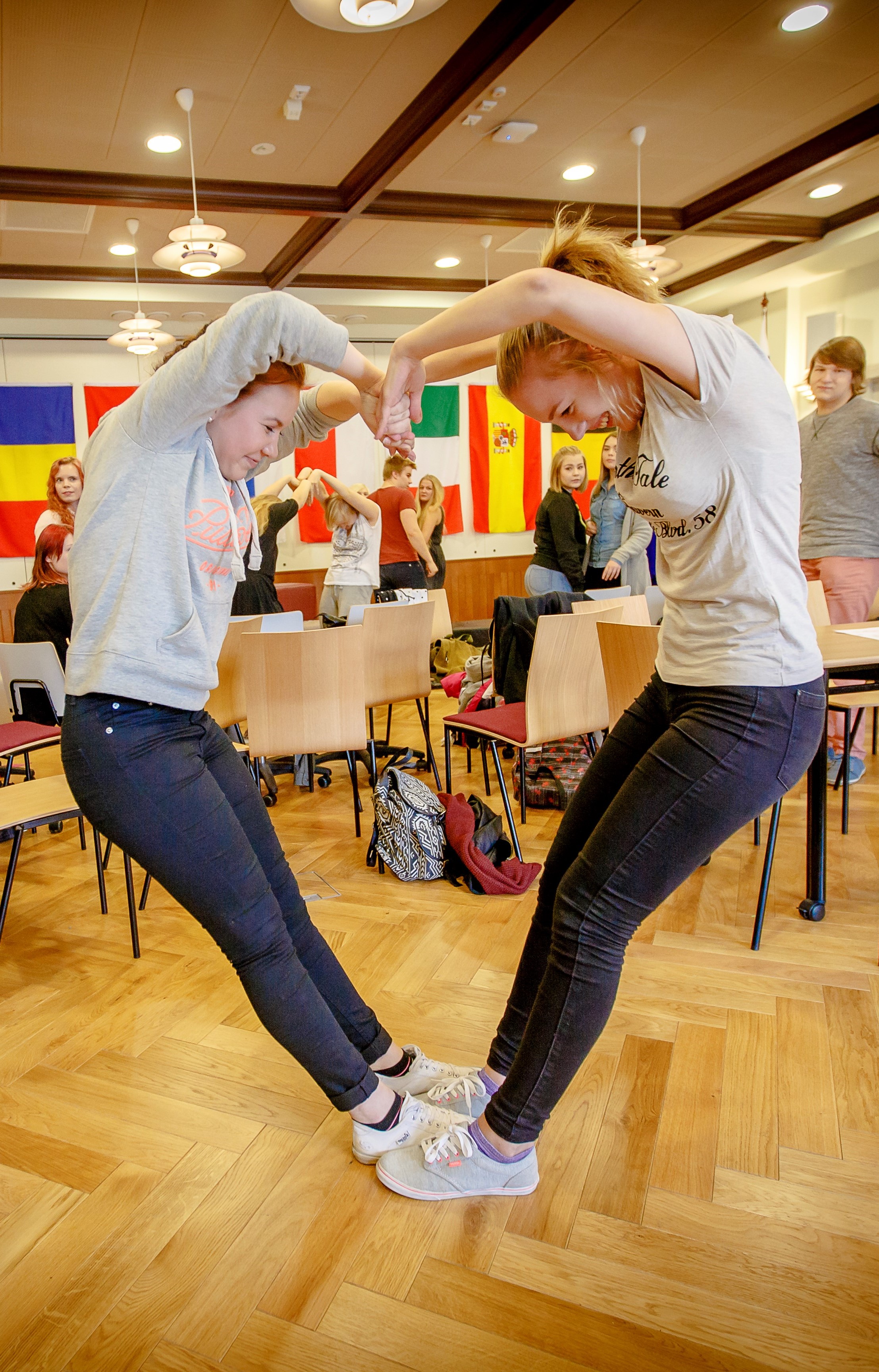 Kaksi opiskelijaa muodostaa kehoillaan sydämen.