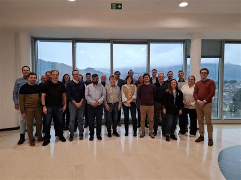 Ryhmä ihmisiä seisoo ikkunoiden edessä.