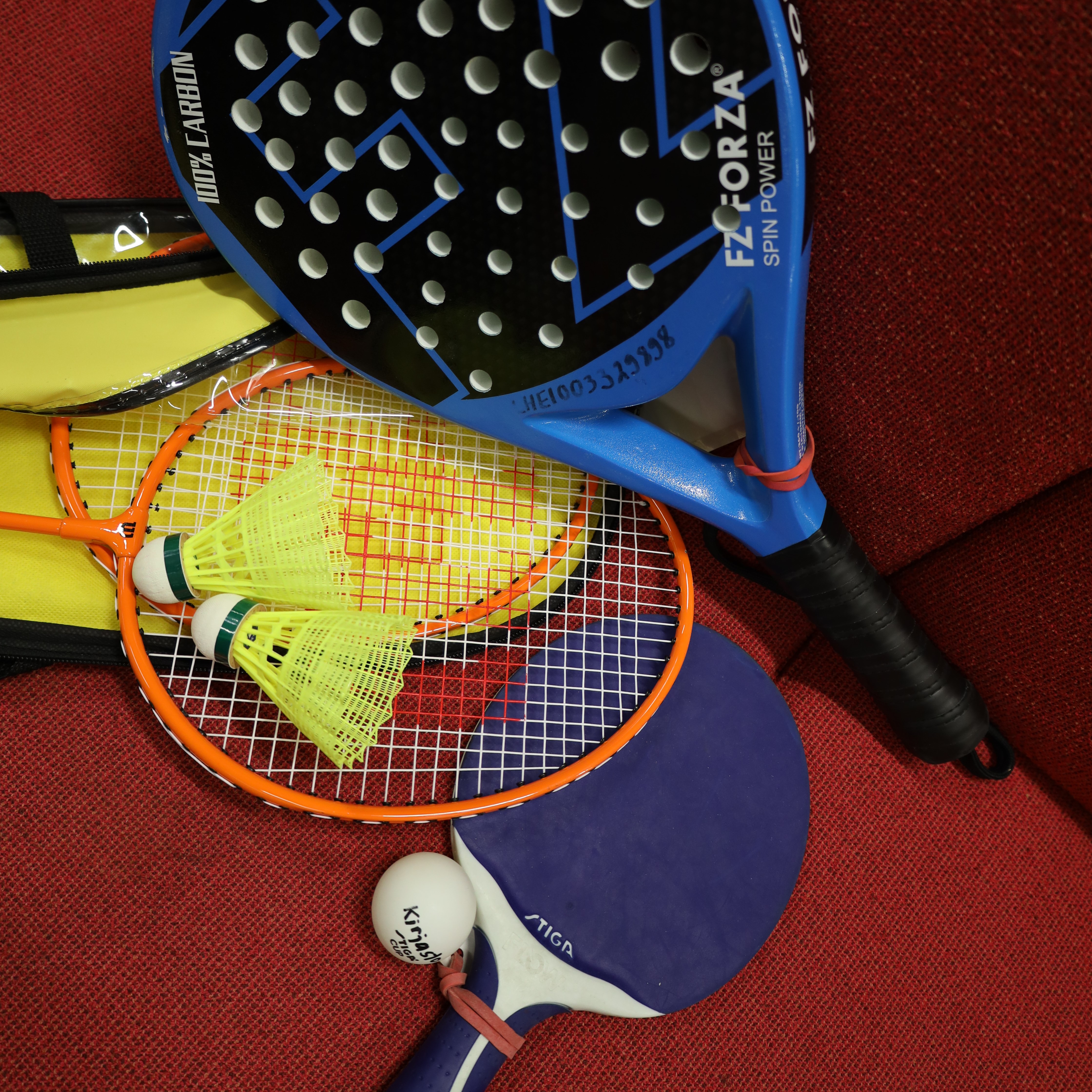 Kuvassa sulkapallo- ja padelmailat sekä -pallot.