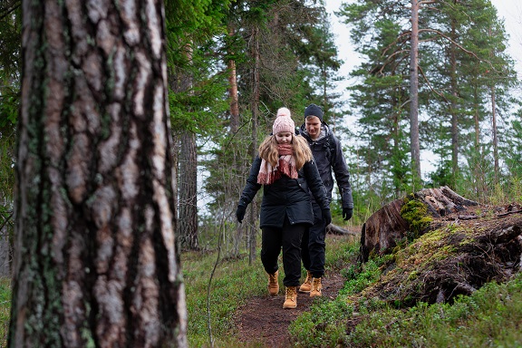 Nainen ja mies kävelevät syksyisessä luonnossa