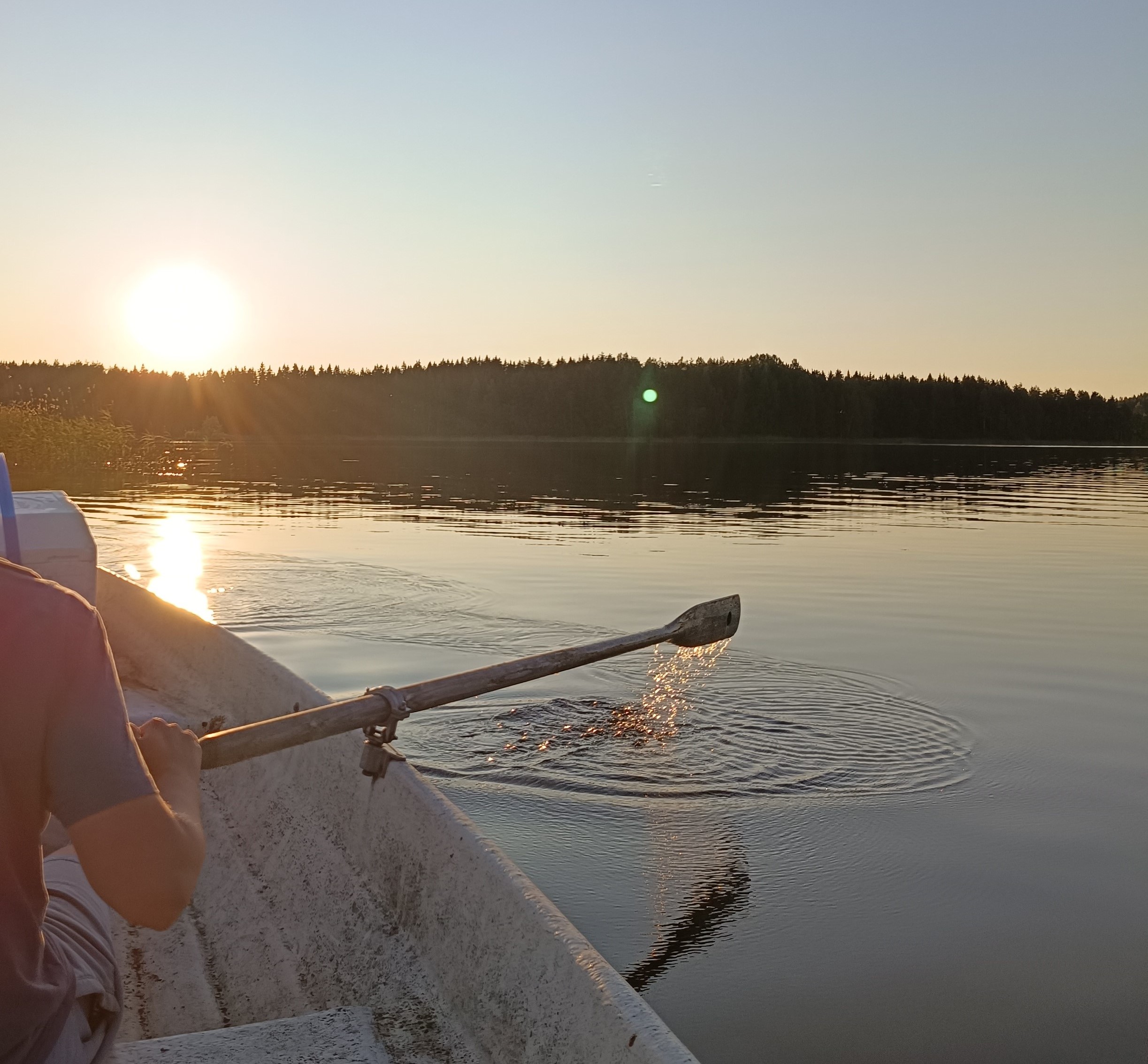 Soutaja, soutuvene ja järvi.