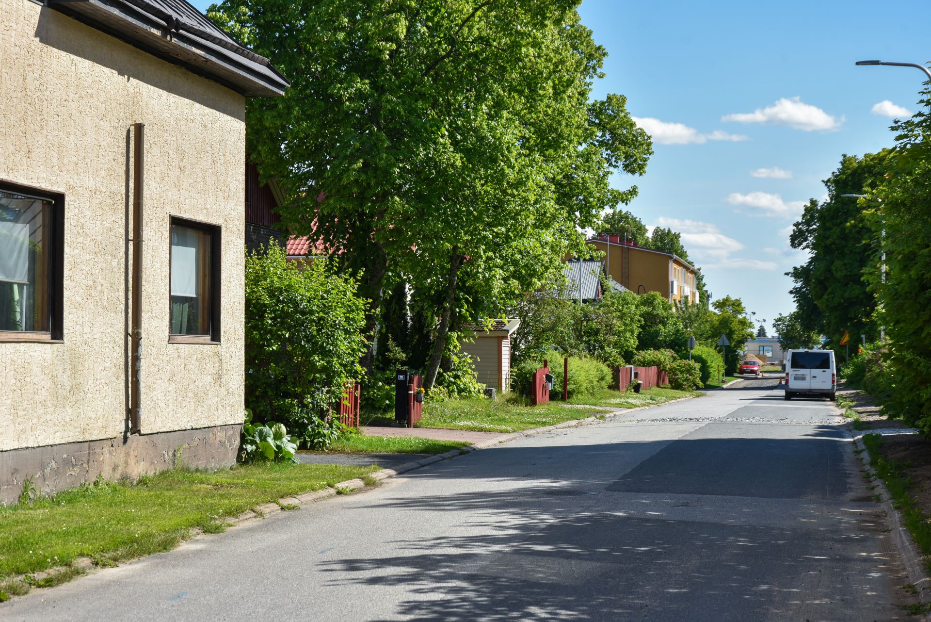 Lappeenrannan Leirin kadunvarressa on autoja, taloja ja puita kesäisessä säässä.
