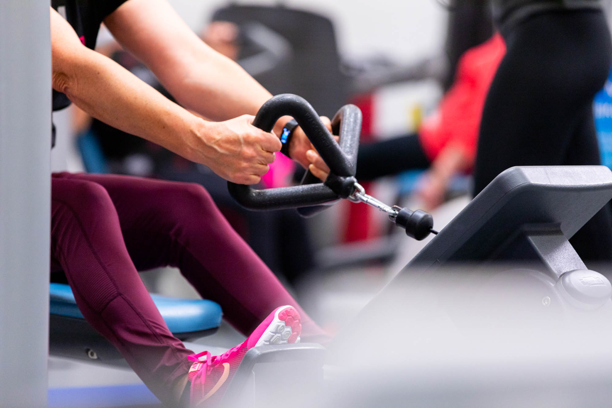 Henkilö kuntosalilaitteessa.