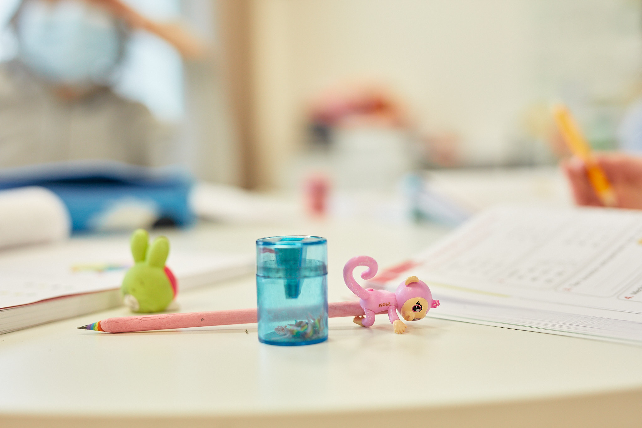 Teroitin, kynä ja pyyhekumi pulpetin päällä koululuokassa.