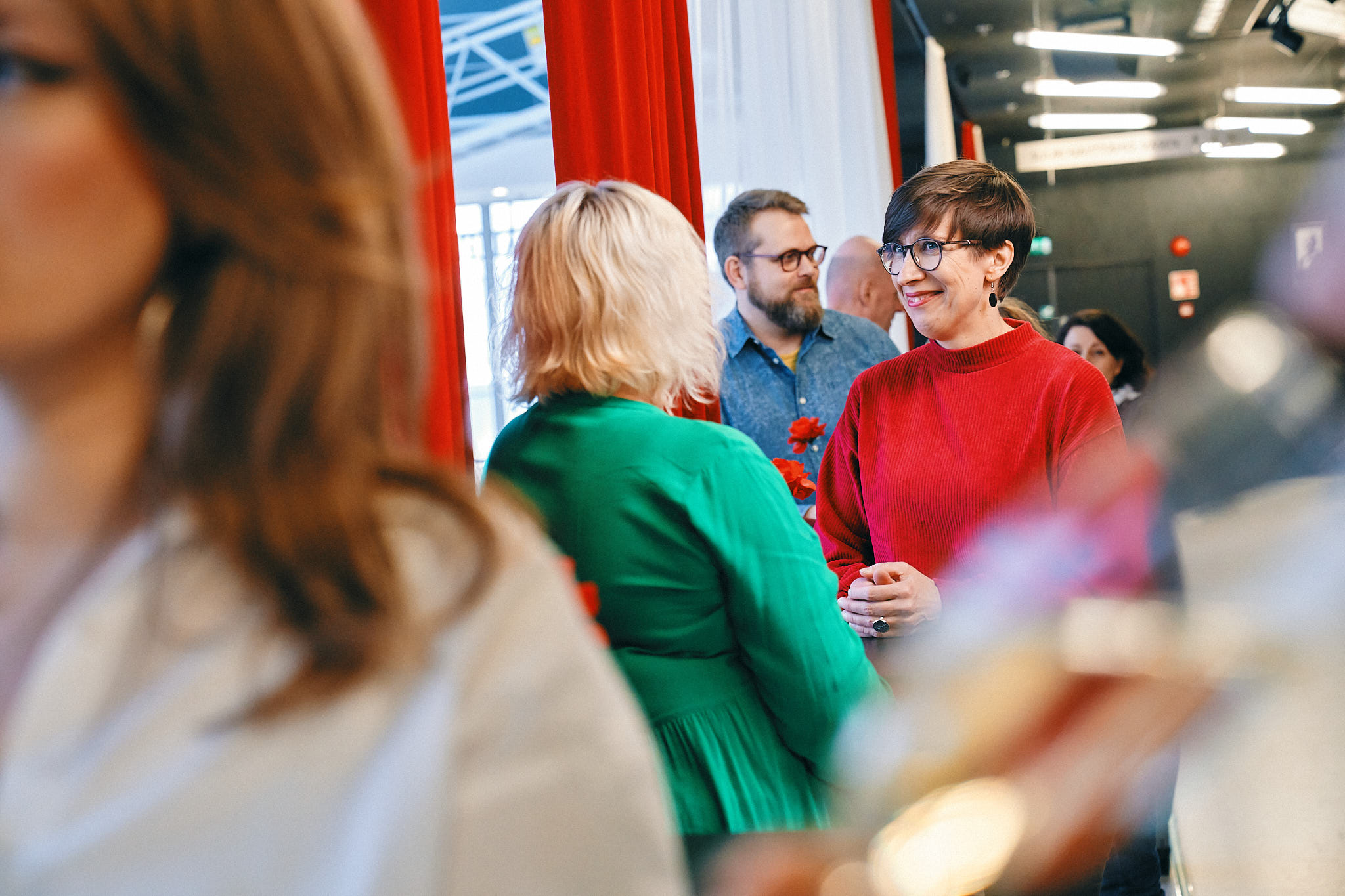 Henkilöitä keskustelemassa teatterin lämpiössä.