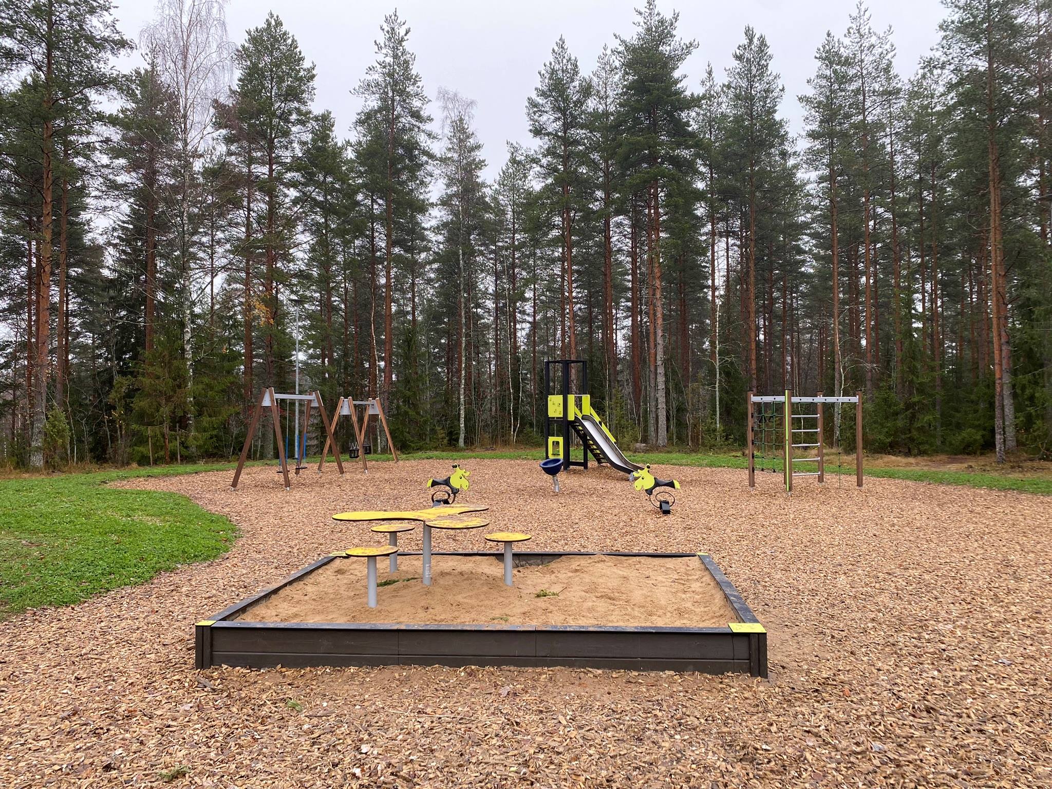 Lasten leikkipaikka, jossa leikkipaikkatelineitä.