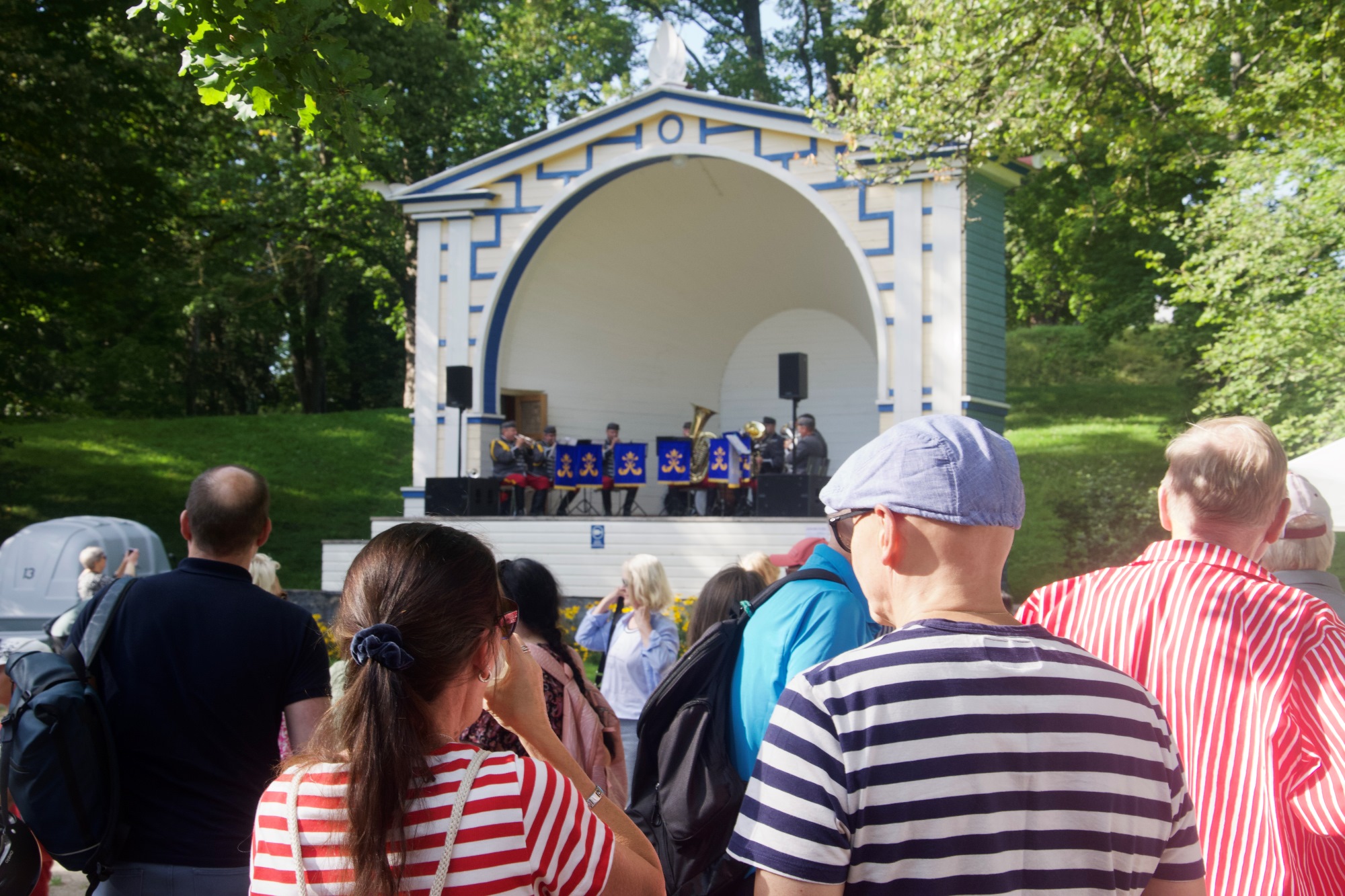 Yleisöä kokoontuneena seuraamaan Rakuunasoittokunnan esitystä Lappeenrannan Pusupuiston lavan edustalla.