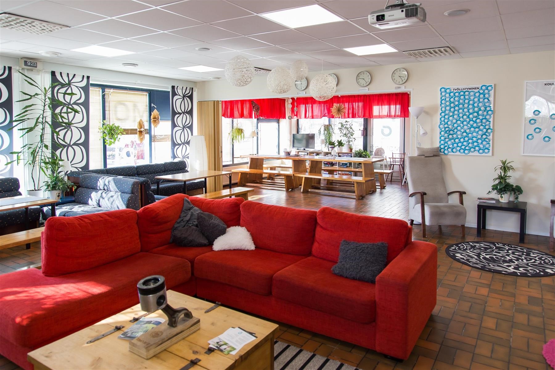  Monarin nuorisotilan oleskeluhuone, jossa etualalla punainen kulmasohva.