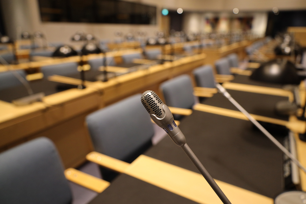 Mikrofoni pöydällä valtuustosalissa.