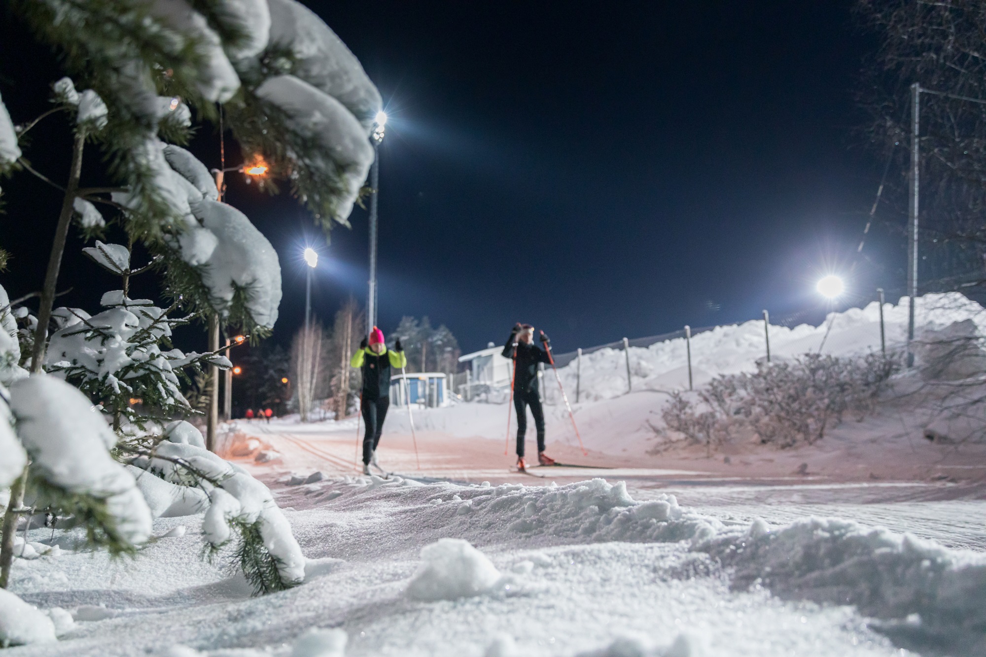 Kaksi henkilöä hiihtämässä ladulla.
