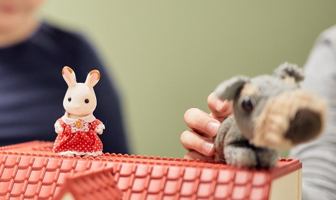 Koira- ja pupulelut nukkekodin katolla päiväkotilapsien leikeissä.