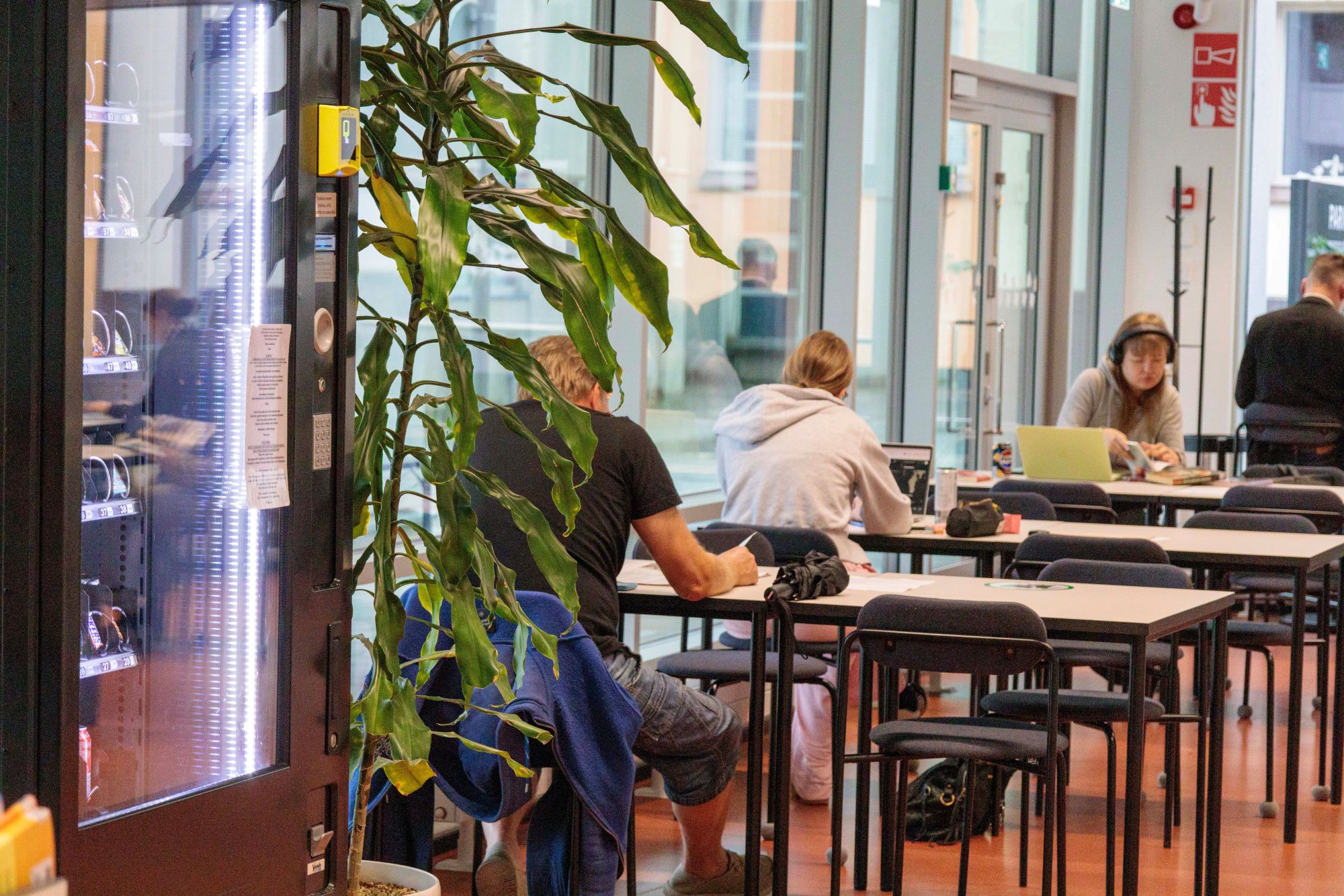 Kirjaston asiakkaita tietokoneiden ja kirjojen ääressä Lappeenrannan pääkirjaston kahvilatilassa.
