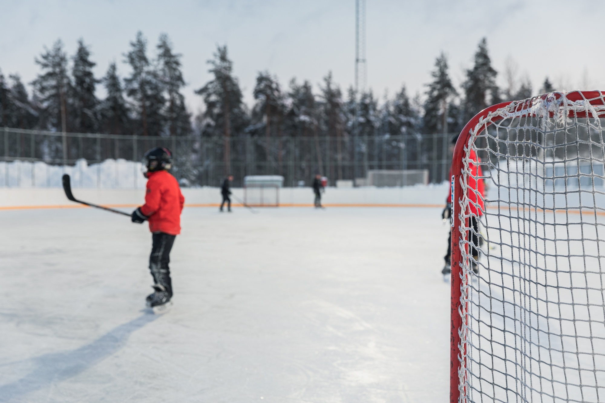 Luistelijoita ja maalikehikot jäällä.
