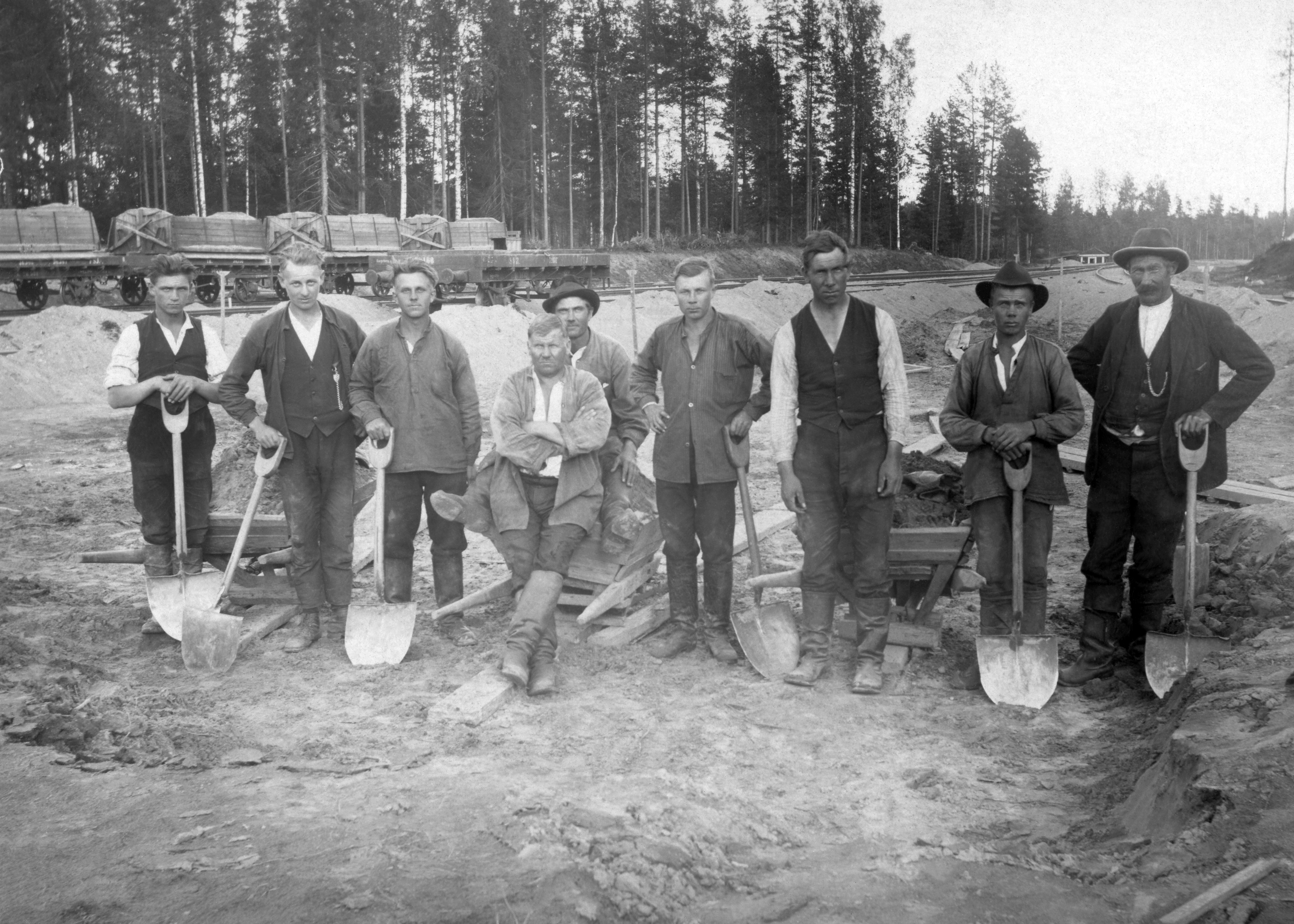 Ratajätkiä rivissä lapioiden kanssa radanrakennustyömaalla.