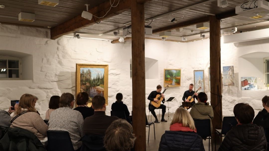 Navettarakennuksessa ihmiset kuuntelemassa konserttia.